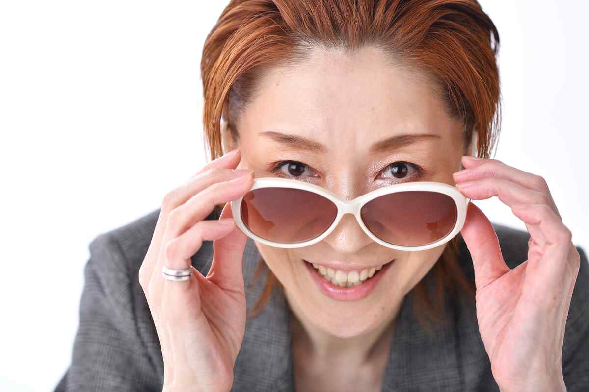 サングラスを外して見つめる越乃リュウさんの写真