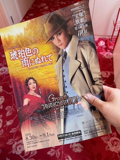 『琥珀色の雨にぬれて』『Grande TAKARAZUKA 110！』のチラシを持った写真